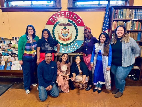 Sapna and NYC Votes staff pose together in front of a sign saying ‘Entering the Bronx’